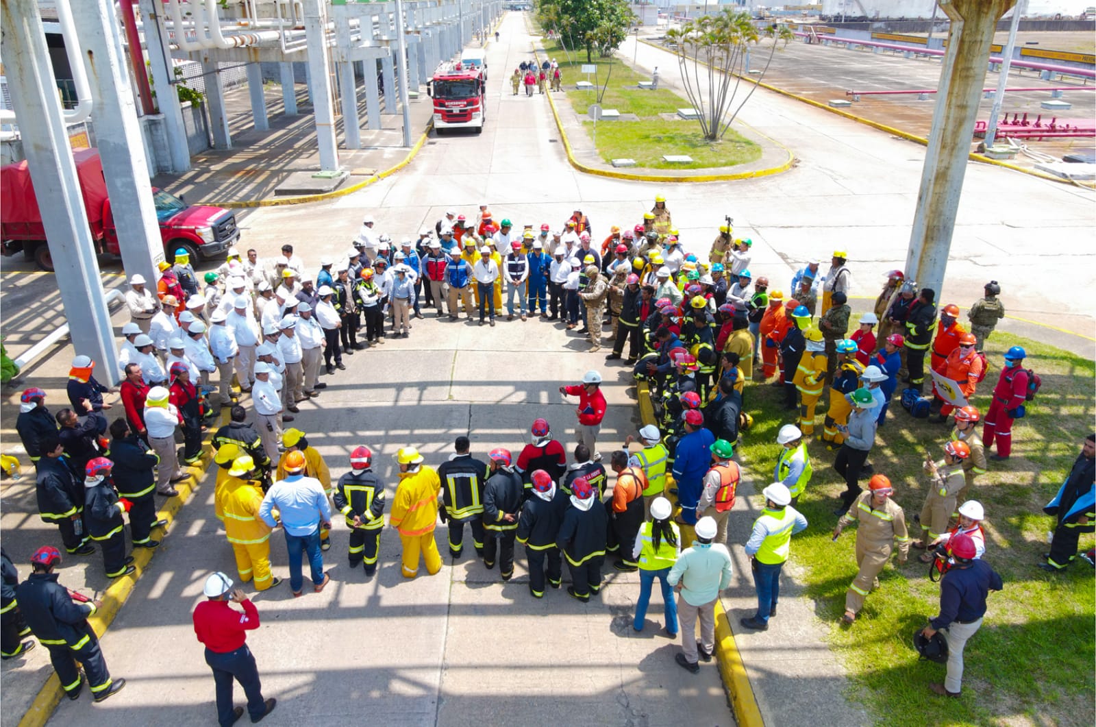 Brigadistas y personal de diferentes equipos se reúnen en un complejo industrial